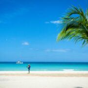 Man playing guitar on 7 mile beach in Jamaica in front of Couples Swept Away resort.